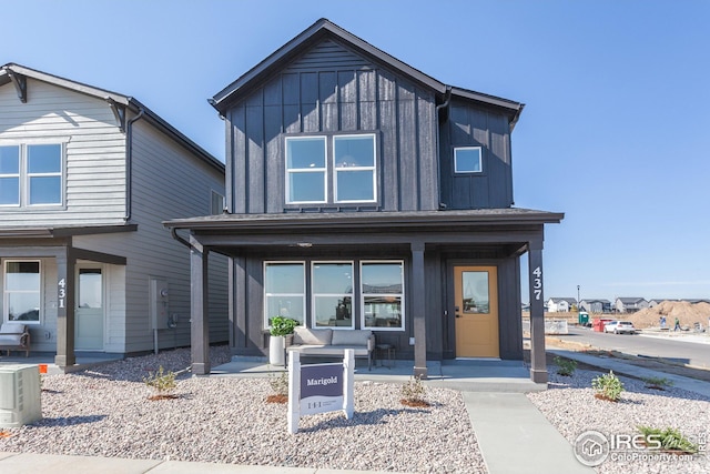 view of front of house featuring a porch, ac unit, and board and batten siding