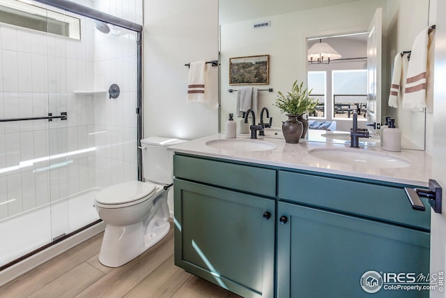 full bath featuring double vanity, visible vents, toilet, and a sink