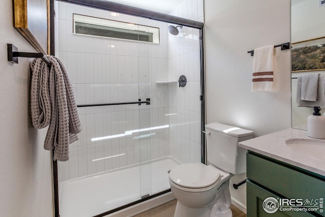 bathroom featuring vanity, toilet, and tiled shower