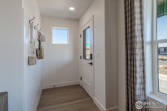 doorway to outside featuring recessed lighting, wood finished floors, and baseboards