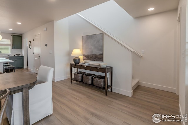 dining room with recessed lighting, baseboards, stairs, and light wood finished floors