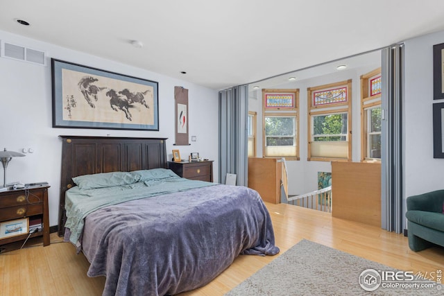 bedroom with visible vents and wood finished floors