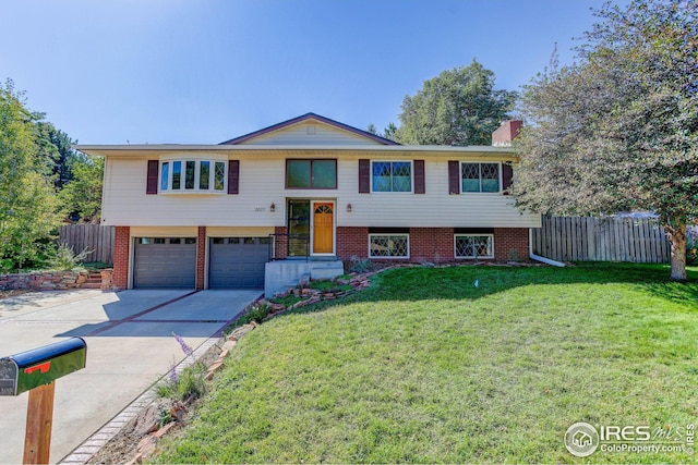 split foyer home featuring a front lawn, fence, brick siding, and driveway