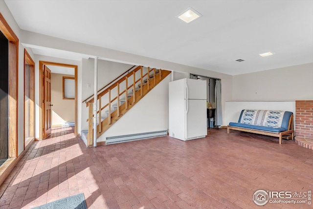 interior space featuring visible vents, freestanding refrigerator, brick floor, a baseboard radiator, and stairs