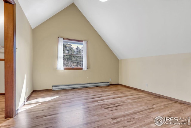 additional living space with lofted ceiling, baseboards, wood finished floors, and a baseboard radiator
