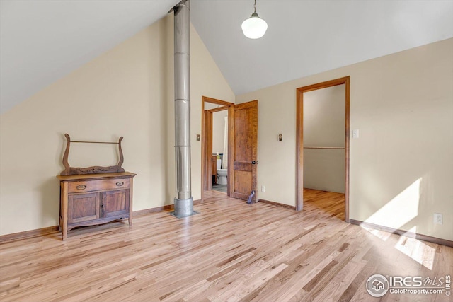 unfurnished bedroom with light wood-style floors, baseboards, and high vaulted ceiling