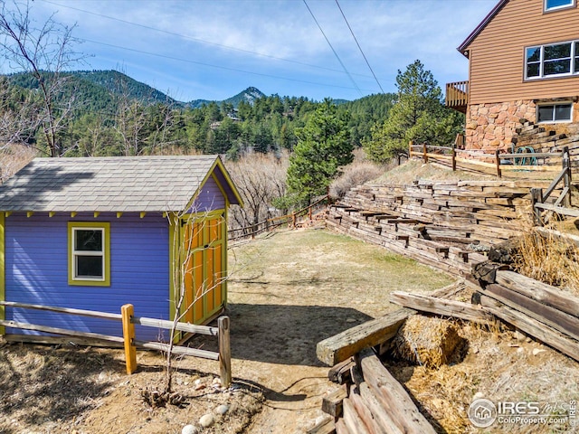 view of yard with a mountain view, an outbuilding, and a storage shed