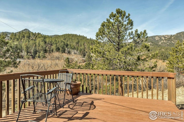 wooden terrace featuring a mountain view and a wooded view