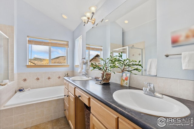 bathroom featuring a sink, a garden tub, a stall shower, and vaulted ceiling