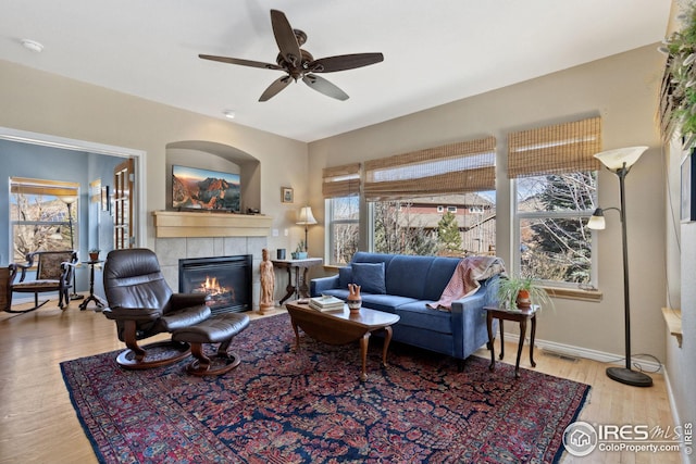107 Bohn Ct, Lyons, CO 80540 - living room with healthy amount of natural light, a tiled fireplace, wood finished floors, and ceiling fan