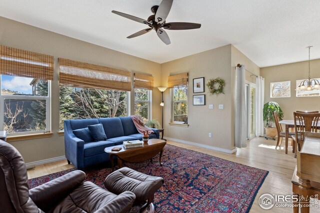 107 Bohn Ct, Lyons, CO 80540 - living room featuring a chandelier, a ceiling fan, wood finished floors, and baseboards