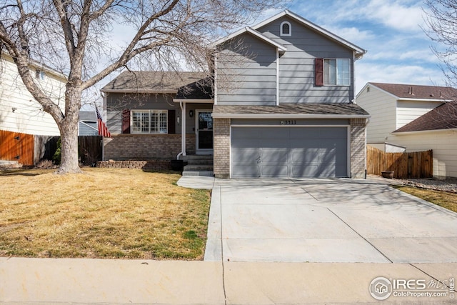 split level home with a front lawn, fence, concrete driveway, an attached garage, and brick siding