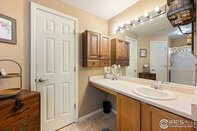 full bath featuring tile patterned floors, visible vents, a shower stall, baseboards, and vanity