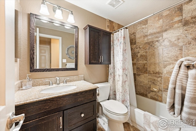 full bath with vanity, toilet, a textured wall, and visible vents