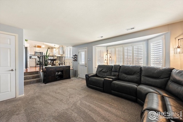 living area featuring visible vents and light carpet