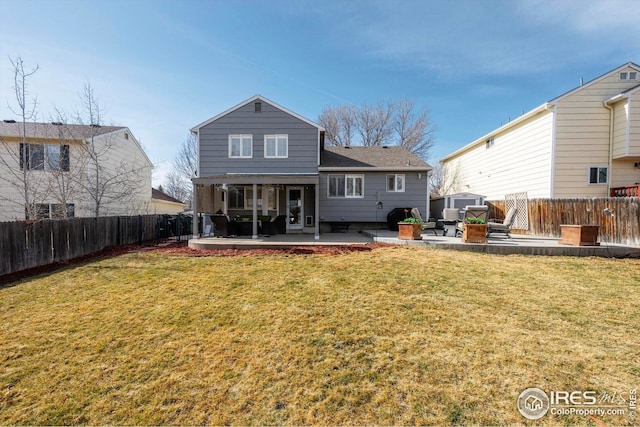 rear view of house with a patio area, a fenced backyard, and a yard