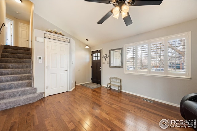 entrance foyer featuring visible vents, stairway, lofted ceiling, a ceiling fan, and wood-type flooring