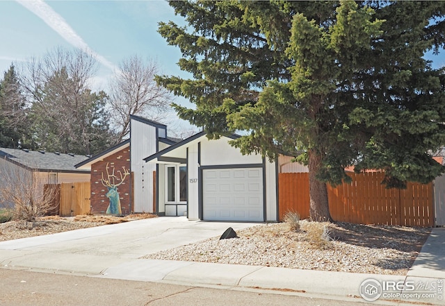 view of front of property with a garage, driveway, and fence