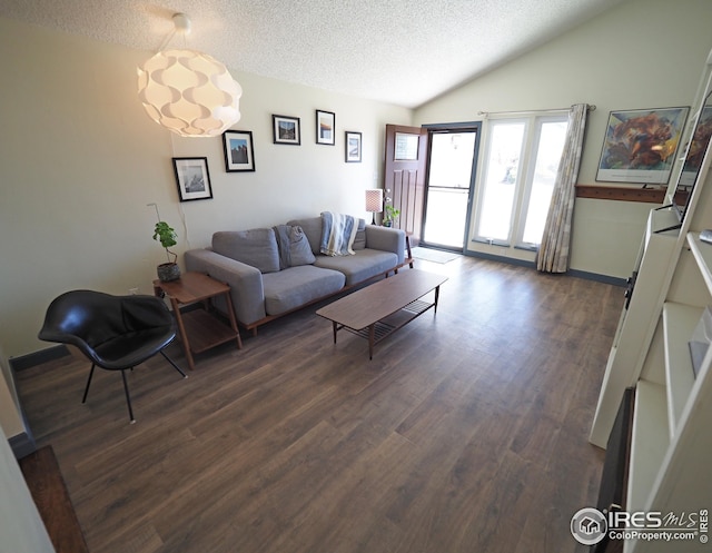 living room featuring a textured ceiling, lofted ceiling, and dark wood-style flooring