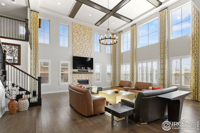 living room featuring coffered ceiling, dark wood finished floors, a fireplace, baseboards, and stairs