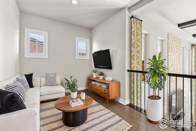 living room featuring baseboards and dark wood-style flooring