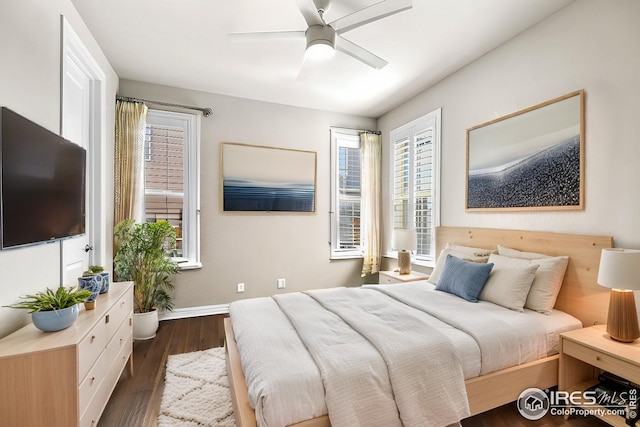 bedroom featuring ceiling fan, baseboards, and dark wood-style flooring