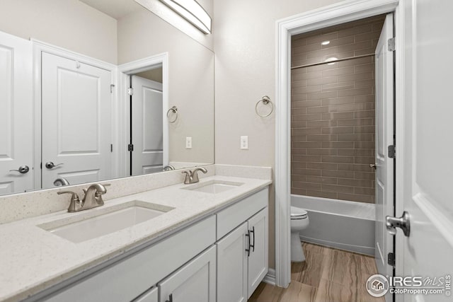 full bathroom with a sink, toilet, bathtub / shower combination, and double vanity