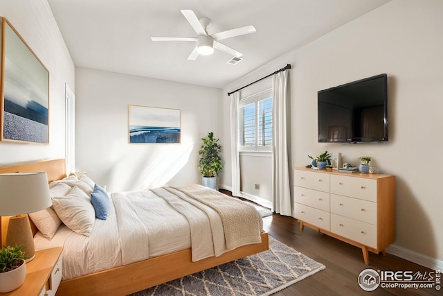 bedroom featuring a ceiling fan, wood finished floors, visible vents, and baseboards