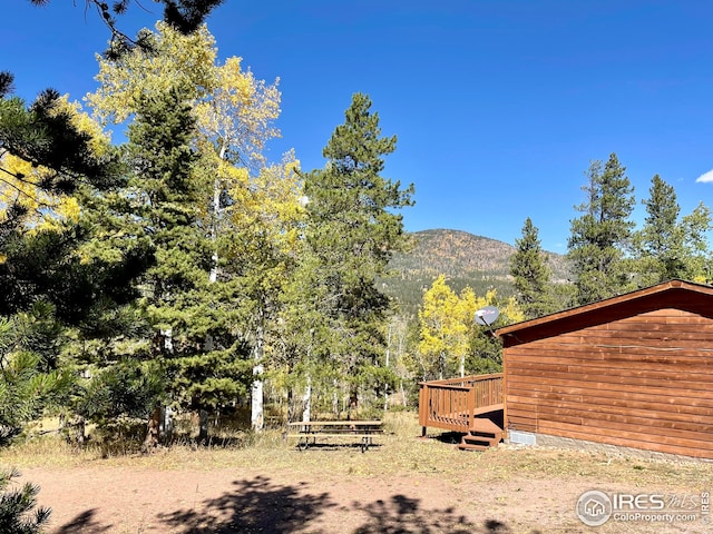 view of yard with a deck with mountain view