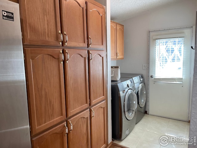 washroom featuring light tile patterned floors, cabinet space, a textured ceiling, and independent washer and dryer