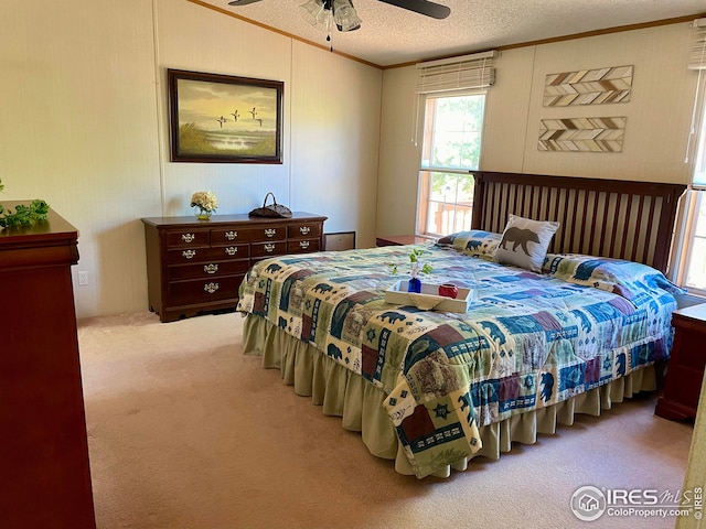 bedroom with a textured ceiling, crown molding, carpet, and a ceiling fan