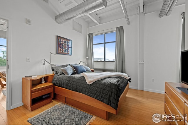 bedroom with light wood-type flooring and baseboards
