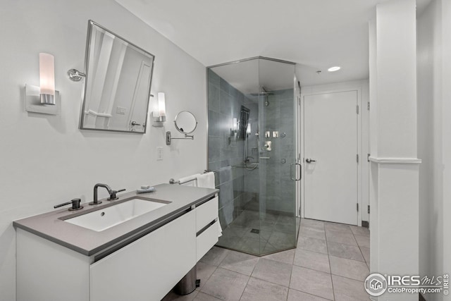 full bathroom featuring tile patterned floors, vanity, and a shower stall