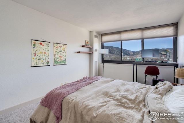 bedroom featuring carpet flooring, visible vents, a mountain view, and baseboards