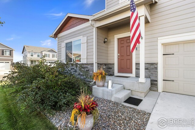 999 Cascade Falls St, Severance, CO 80550 - entrance to property featuring stone siding and a garage