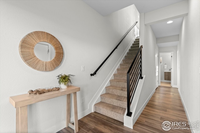 stairway featuring baseboards and wood finished floors