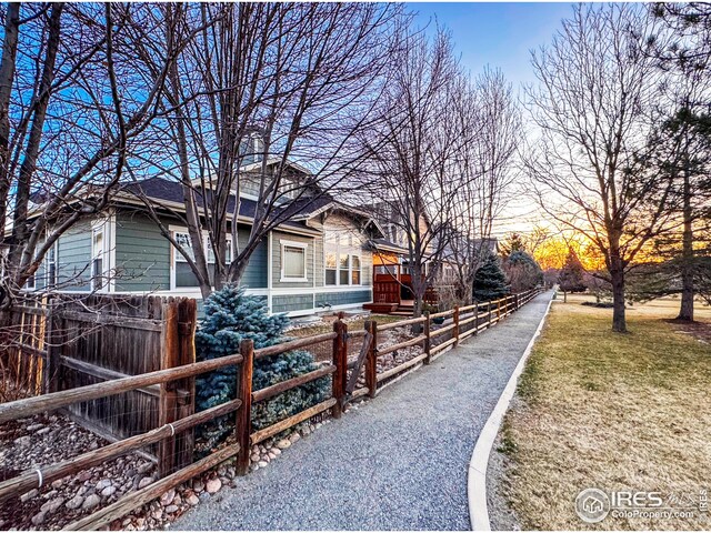 view of home's exterior with a lawn and fence