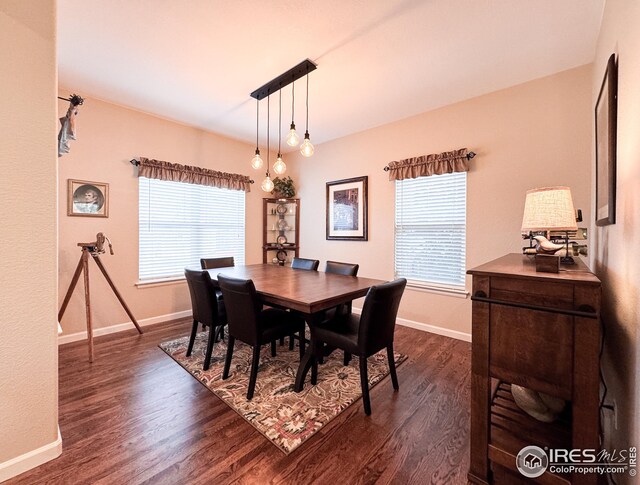 dining area with dark wood-type flooring and baseboards