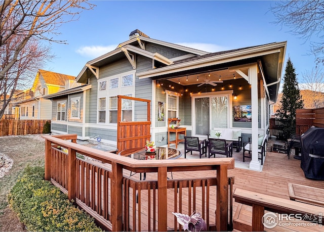 deck featuring outdoor dining area, ceiling fan, and fence