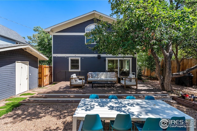 back of property with an outdoor hangout area, a deck, and fence
