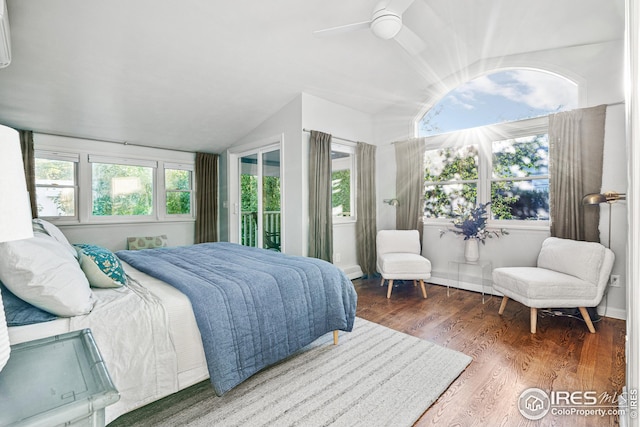 bedroom with a ceiling fan, lofted ceiling, wood finished floors, and baseboards