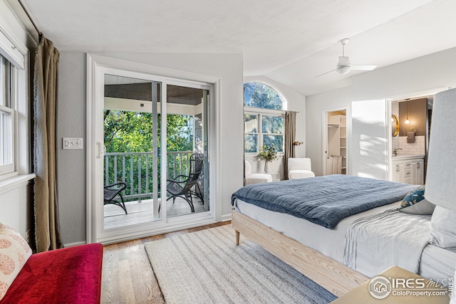 bedroom with wood finished floors, ensuite bath, ceiling fan, access to exterior, and vaulted ceiling