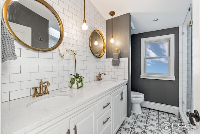 bathroom featuring a baseboard heating unit, toilet, decorative backsplash, tile patterned floors, and a sink