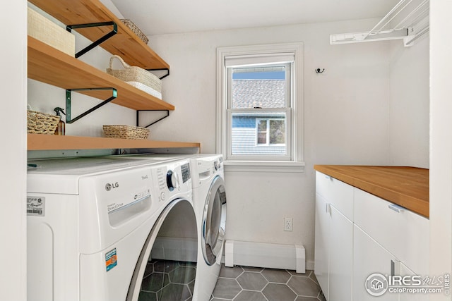 laundry room featuring baseboards, dark tile patterned flooring, cabinet space, a baseboard heating unit, and washer and clothes dryer