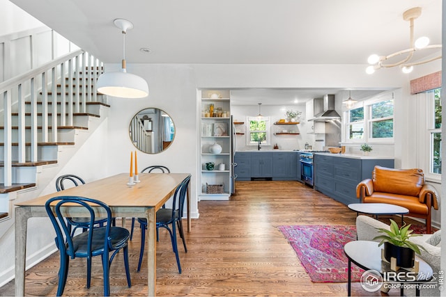 dining area with a notable chandelier, light wood-style floors, a healthy amount of sunlight, and stairs