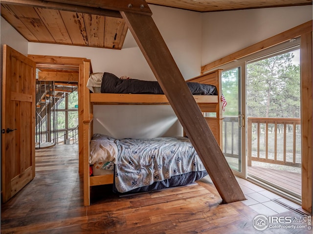 bedroom with access to outside, multiple windows, wooden ceiling, and wood finished floors