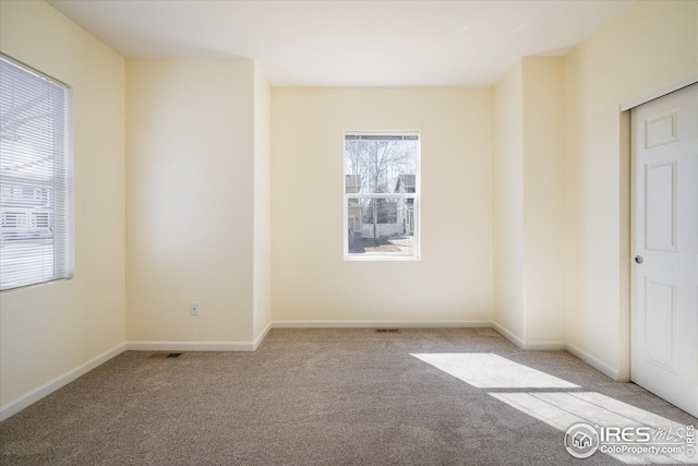 spare room featuring baseboards and carpet