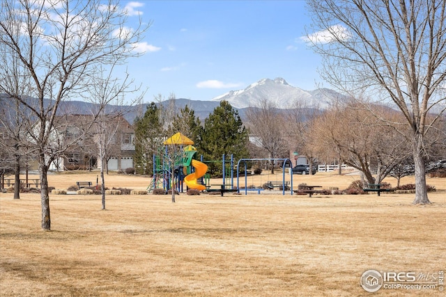 view of property's community featuring a mountain view, a yard, and playground community