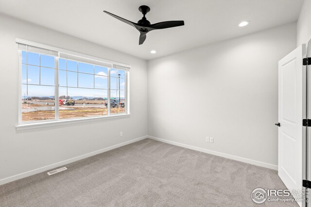 carpeted empty room with recessed lighting, a ceiling fan, and baseboards