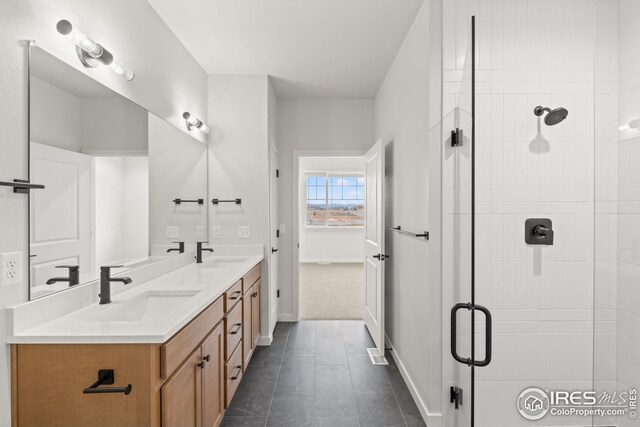 bathroom with a sink, a stall shower, double vanity, and tile patterned flooring